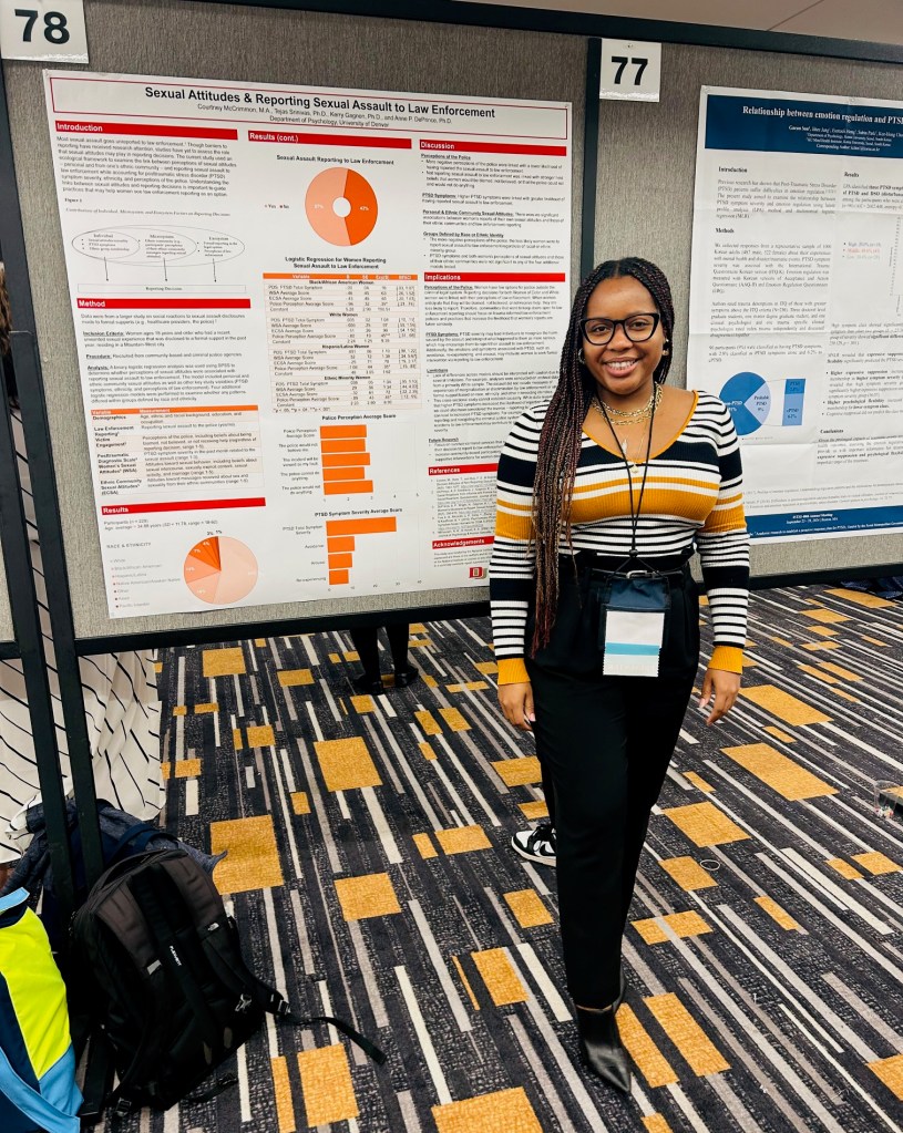 Graduate student Courtney McCrimmon stands with her poster at a conference. 